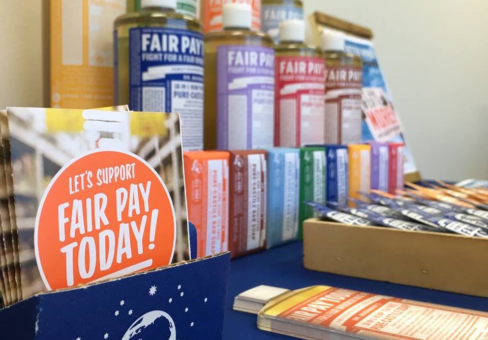 Fair Pay Today booth setup with information and Dr. Bronner's products.